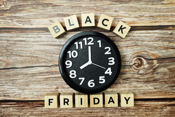 Black Friday with Clock on wooden background
