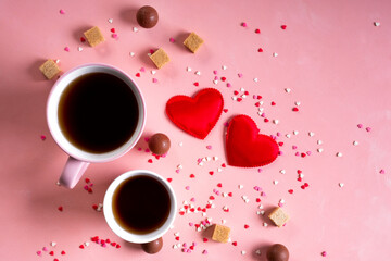 Love drinks. Coffee tea cups for two, sweets candy chocolate on pink hearts background. Valentines day 14 february minimal concept