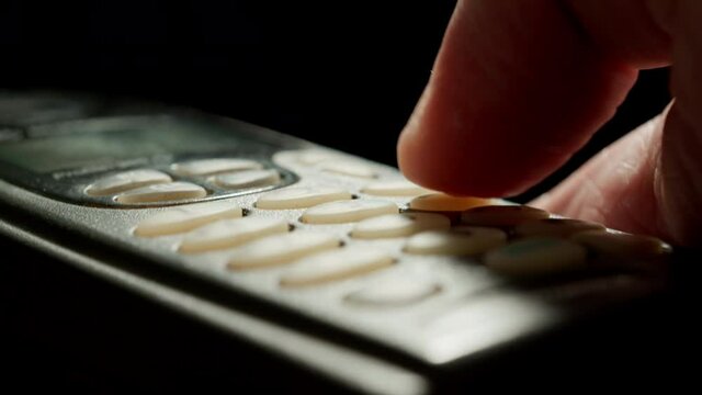 Man hand old using old mobile phone. Outdated push button cellphone. Close up.