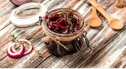 Homemade onion marmalade jam, confiture, chutney on a rustic wooden table. Delicious sauce. French cuisine