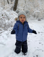 Cute Moroccan toddler boy walking in snow for first time while hiking