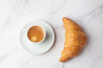 strong cup of coffee and fresh croissant.