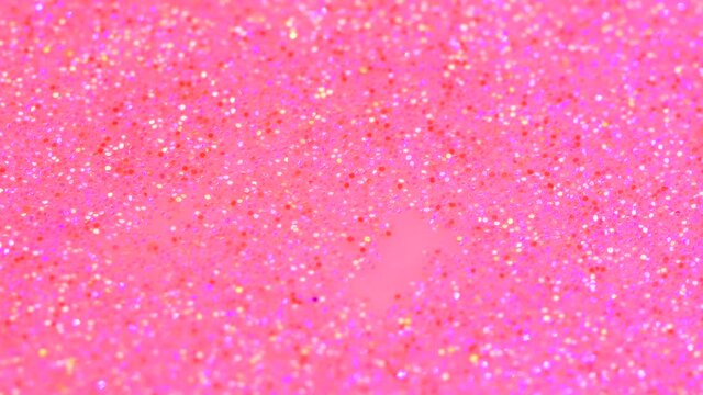 Water drop falling into beautiful pink rose neon glitter surface and splashing