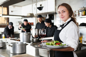 Waitress holding cooked meals at kitchen restaurant. High quality photo