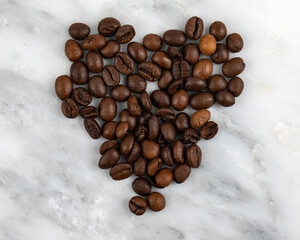 Fresh Coffee Beans from Above Close Up in a shape of a Heart on a Marble Texture Background