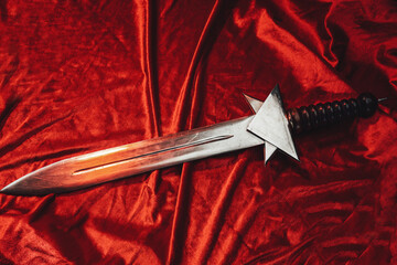 Flawless short roman sword its on red cape. Single bronze gladius on floor its using by imperial...