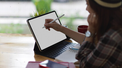 Female teenager using mock up digital tablet on bar in coffee shop