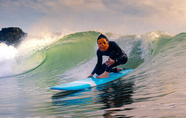 Halloween Costume Surfing Various scary costumes worn by a surfer while riding waves in Japan. Pumpkin, Monster, clown, witch. The waves are clean with a good looking sunrise as well