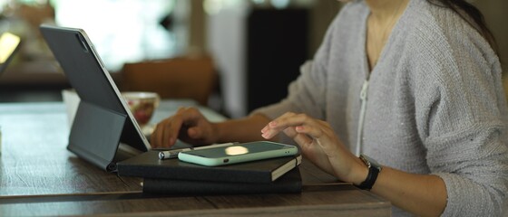 Female freelancer hand working with digital tablet, notebook and smartphone