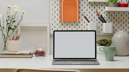 Home office with laptop, books, stationery, copy space and flower, clipping path