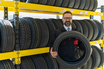 Portrait of senior man mechanic in tires shop services. Good service and professional tires shop...