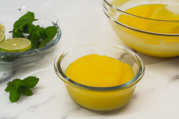 Lemon pudding with fresh mint leaves and sliced lemon recipe. Ingredients close up on marble background