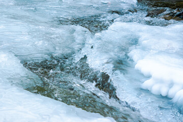 ice texture on the river. close up background. blue color in day light. water flow among cracks