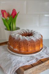 Fresh vanilla bundt cake on a wooden cutting board