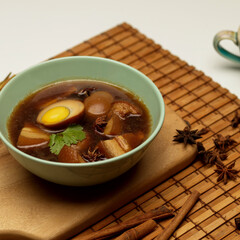Sweet brown stewed eggs soup (Kai Palo) with pork on bamboo placemat
