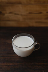  a glass of milk on a dark wooden background