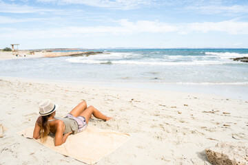 Fototapeta na wymiar Pretty woman sunbathing on the beach.