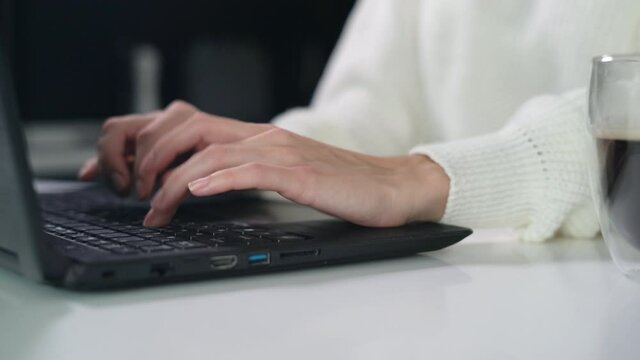 Female hands of business woman professional user worker using typing on laptop notebook keyboard sit at home office desk working online with pc software apps technology concept, close up side view