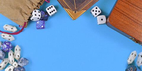Banner with tabletop role playing items like blue and white RPG dices, character sheet and rule books with empty copy space on blue background in middle - obrazy, fototapety, plakaty