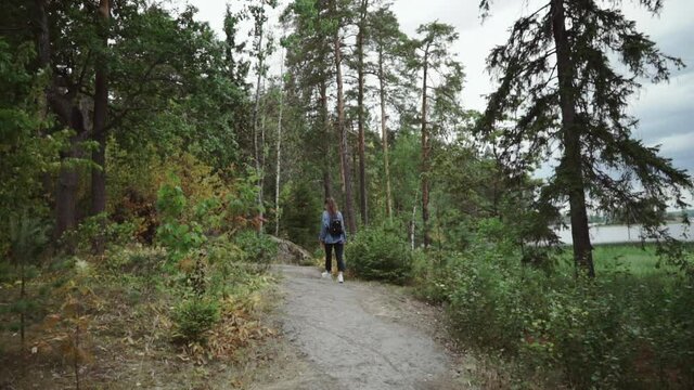 Young caucasian girl walking in park or forest