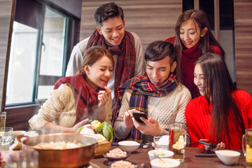 happy young group   watching the smart phone in the restaurant