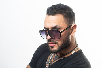 Handsome confident man. Serious guy posing in studio. Fashion young male model with sunglasses and confident face. Close up face, portrait.