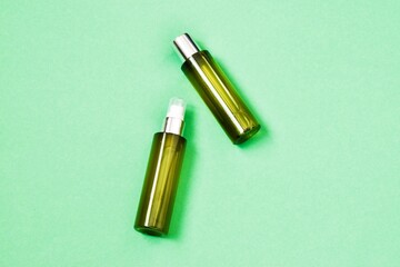 Skin care cosmetic bottles on green background. Advertising cosmetics product. Bio beauty products packaging design. Flat lay, top view. Concept beauty. Copy space.