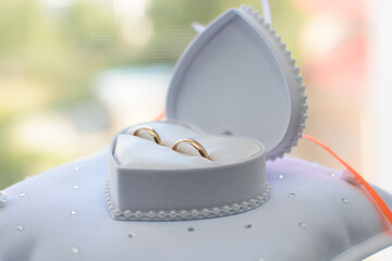 two gold wedding rings lie in a white box
