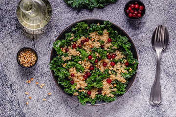 Healthy raw kale and quinoa salad with cranberry and pine nut.