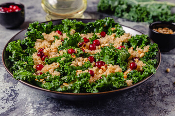Healthy raw kale and quinoa salad with cranberry and pine nut.