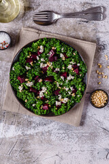 Healthy raw kale and beetroot salad with feta cheese and pine nut.