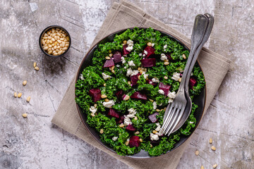 Healthy raw kale and beetroot salad with feta cheese and pine nut.