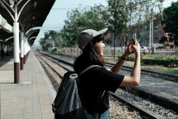 Woman using smartphone at train station.