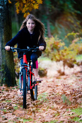 cute little girl on her bicycle in the garden or in nature