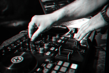 hands DJ playing and mixing music on music controller at a party