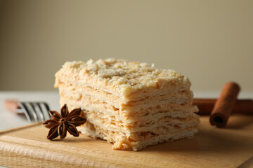 Wooden board with piece of Napoleon cake with cinnamon, close up