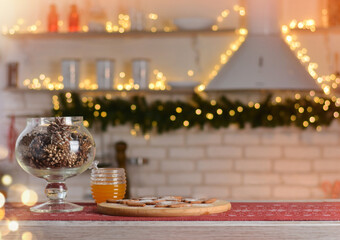 Happy New Year and Merry Christmas! Christmas kitchen. Wooden table with gingerbread, honey, shiksha. Beautiful bokeh in the background.Copy space for text
