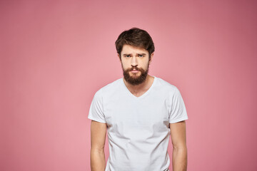 Obraz premium Man in white t-shirt emotions lifestyle facial expression cropped view pink background.