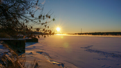 frosty winter over the river, sunset
