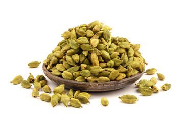 Isolated heap of cardamom on the wooden plate