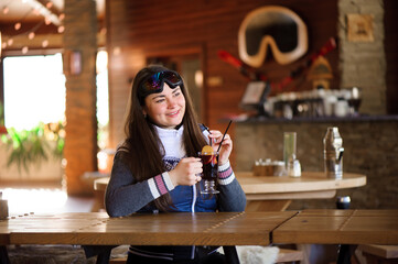 girl resting and drinking hot tasty mulled wine in a cafe ski resort