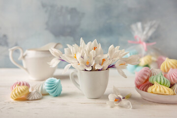 Still life with a bouquet of crocuses, a plate of colorful meringues and a milkman . Good morning greeting card.