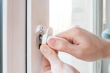 Crack in the window handle mechanism. Man tries to fix