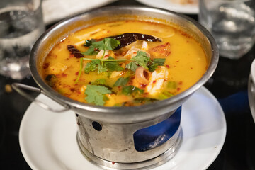 Tom Yum kung with herb on hot pot. Spicy Thai traditional food