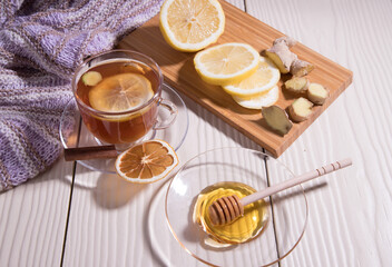 Warming vitamin tea with lemon and ginger in a glass Cup, white background. Horizontal orientation.