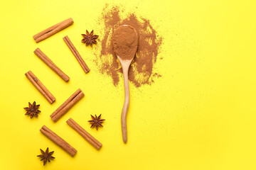 Cinnamon sticks, spoon with powder and anise on color background