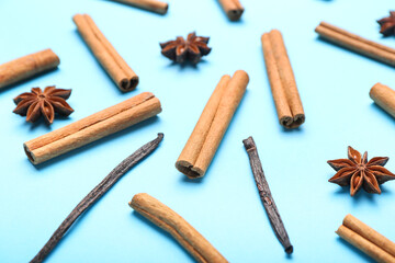 Cinnamon sticks, vanilla and anise on color background