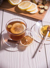 Vitamin tea with lemon, honey and ginger on a cutting Board in a glass Cup, white background.Close up. Vertical orientation.