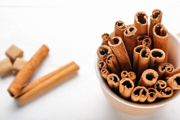 Cup with cinnamon sticks on table