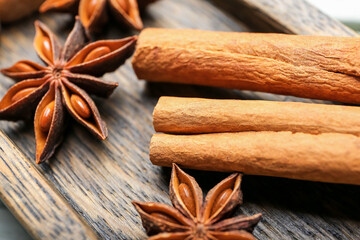 Cinnamon sticks and anise on wooden plate, closeup